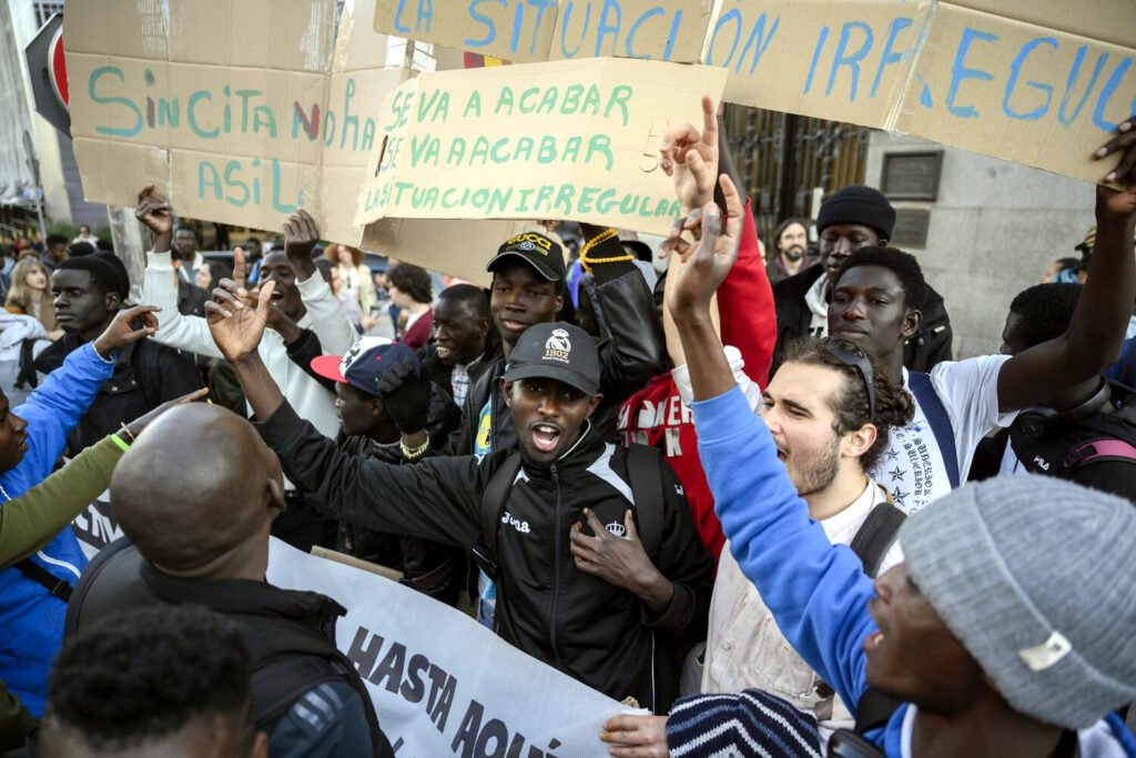 Personas migrantes celebraban frente al Congreso la toma en consideración de la ILP Regularización Ya, en abril de 2024. Álvaro Minguito.