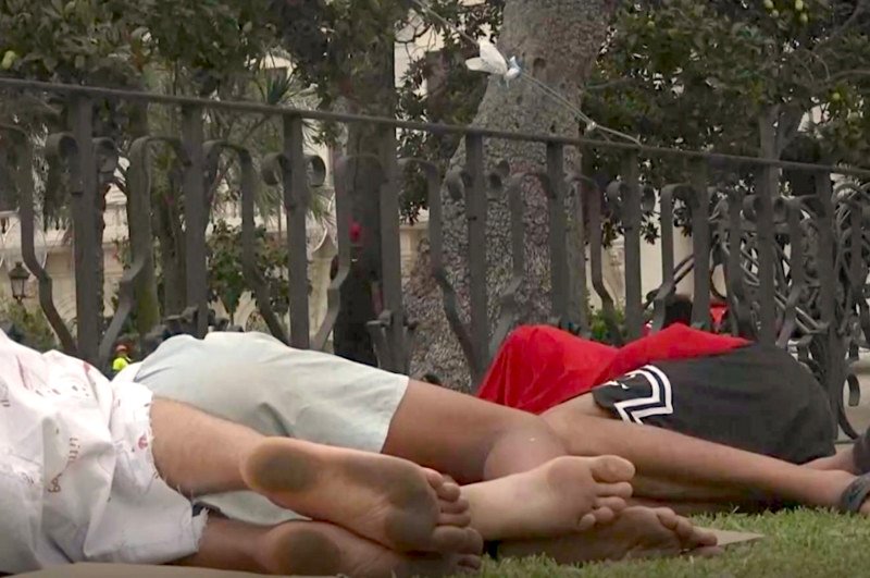 Tres personas durmiendo en las calles de Ceuta tras cruzar desde Marruecos el 30 de julio de 2026.