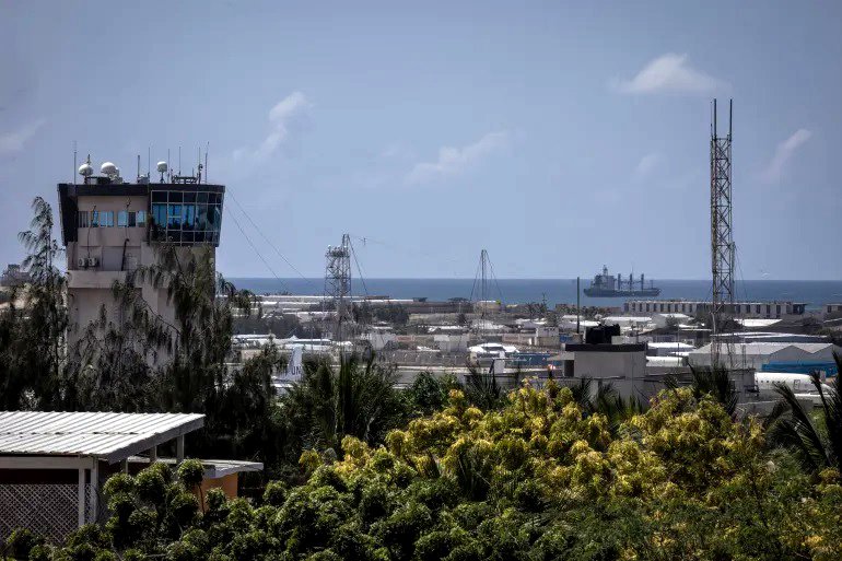 Una torre de control de tráfico aéreo y un buque mercante se ven en el aeropuerto de Mogadiscio, Somalia.