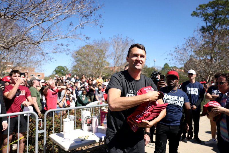 Charlie Kirk reparte gorras en el evento de su American Comeback Tour en la Florida State University en febrero de 2025.