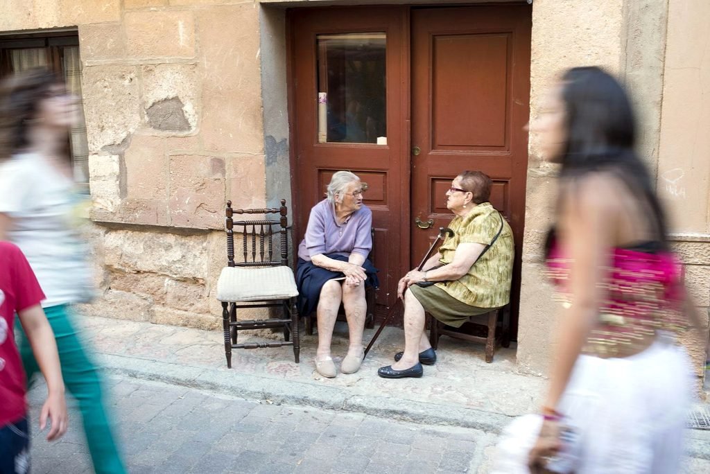 Dos mujeres conversan en la puerta de una casa en un pueblo segoviano. Fotografía: Álvaro Minguito.