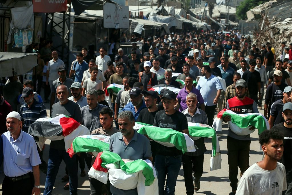 Los dolientes portan los restos de miembros de tres familias durante el funeral de casi 100 personas, entre ellas 70 niños, que murieron en ataques israelíes y cuyos cuerpos fueron recuperados por equipos de la Defensa Civil Palestina de entre los escombros en el barrio de Zeitoun, en la ciudad de Gaza, el 6 de septiembre de 2026. (Yousef Zaanoun/Activestills).