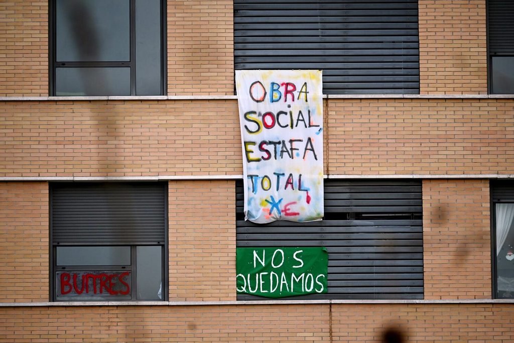 Pancartas en el bloque del Ensanche de Vallecas, antes de la Obra Social La Caixa y ahora comprado por fondos buitre. Fotografía de Diana Moreno.