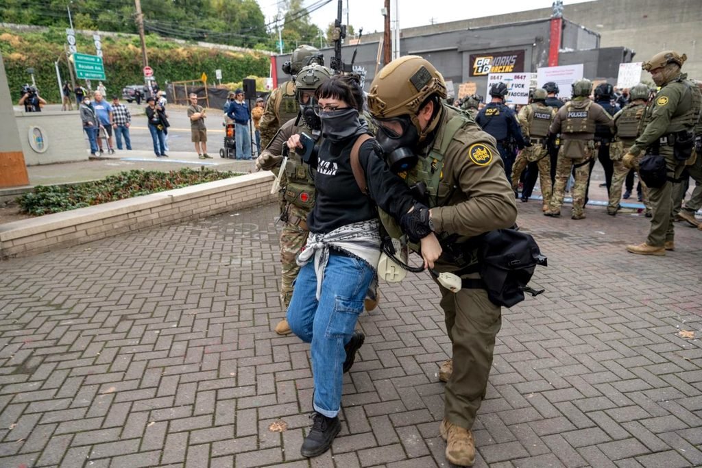 Un agente de la Patrulla Fronteriza de EEUU (derecha) y un agente del ICE detienen a un manifestante frente de las instalaciones del ICE en octubre de 2025 en Portland, Oregón.