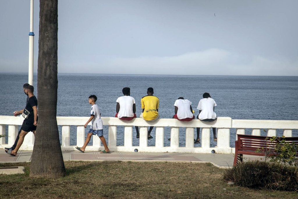Unos chicos miran hacia el mar en el paseo cercano a playa Benítez. Fotografía de Jaime Cinca.