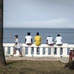 Unos chicos miran hacia el mar en el paseo cercano a playa Benítez. Fotografía de Jaime Cinca.