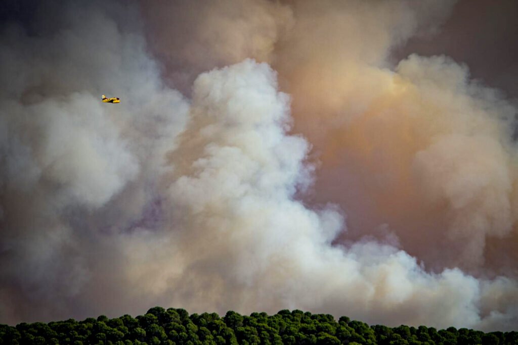 Vecinas de un pueblo de Huelva contemplan el avance de las llamas del incendio de Niebla.