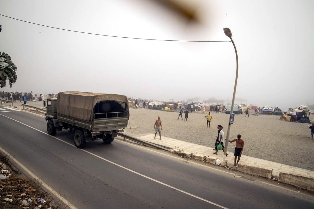 Vista general de la playa del Trampolín mientras un camión militar pasa por la carretera anexa.