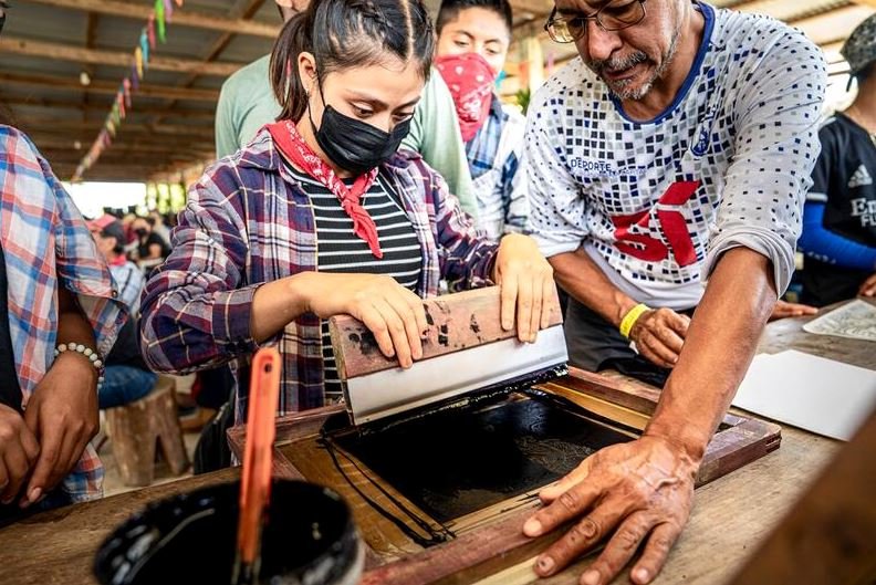 Jóvenes y jóvenas bases de apoyo zapatistas participan del taller de serigrafía durante el encuentro 'ResignArte u OrganizArte', en el Semillero Comandanta Ramona del Caracol de Morelia.