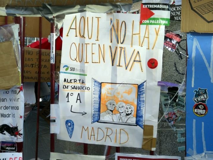 Cartel de 'Aquí no hay quien viva' situado debajo del Oso y el Madroño. Ariadna Ruiz.