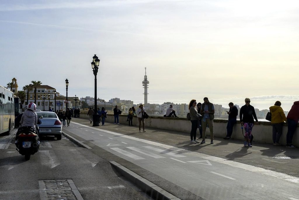 Distintas personas caminan por el paseo marítimo de Cádiz. Fotografía de Álvaro Minguito.